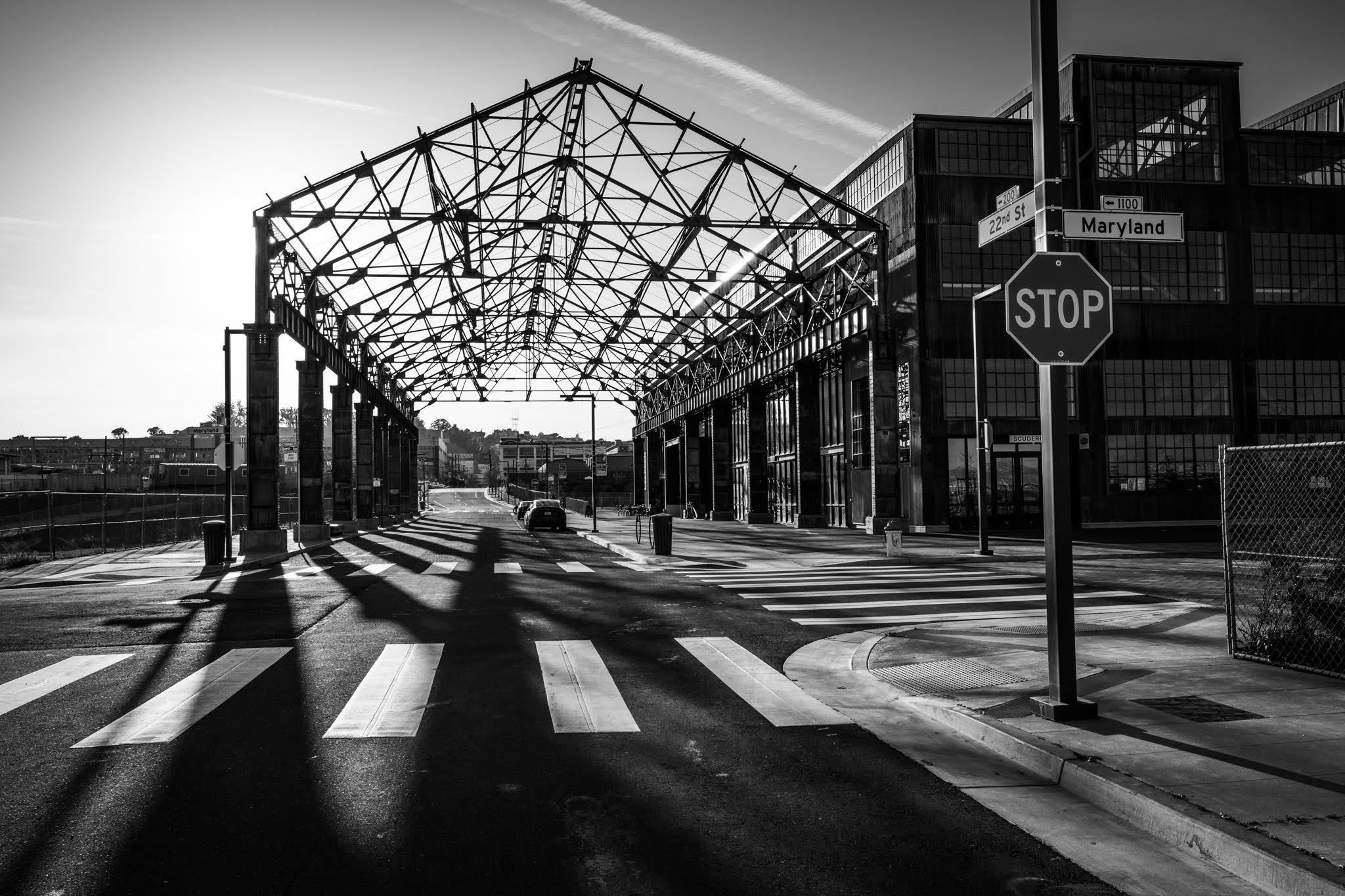 Steel canopy structure casting long shadows across empty road