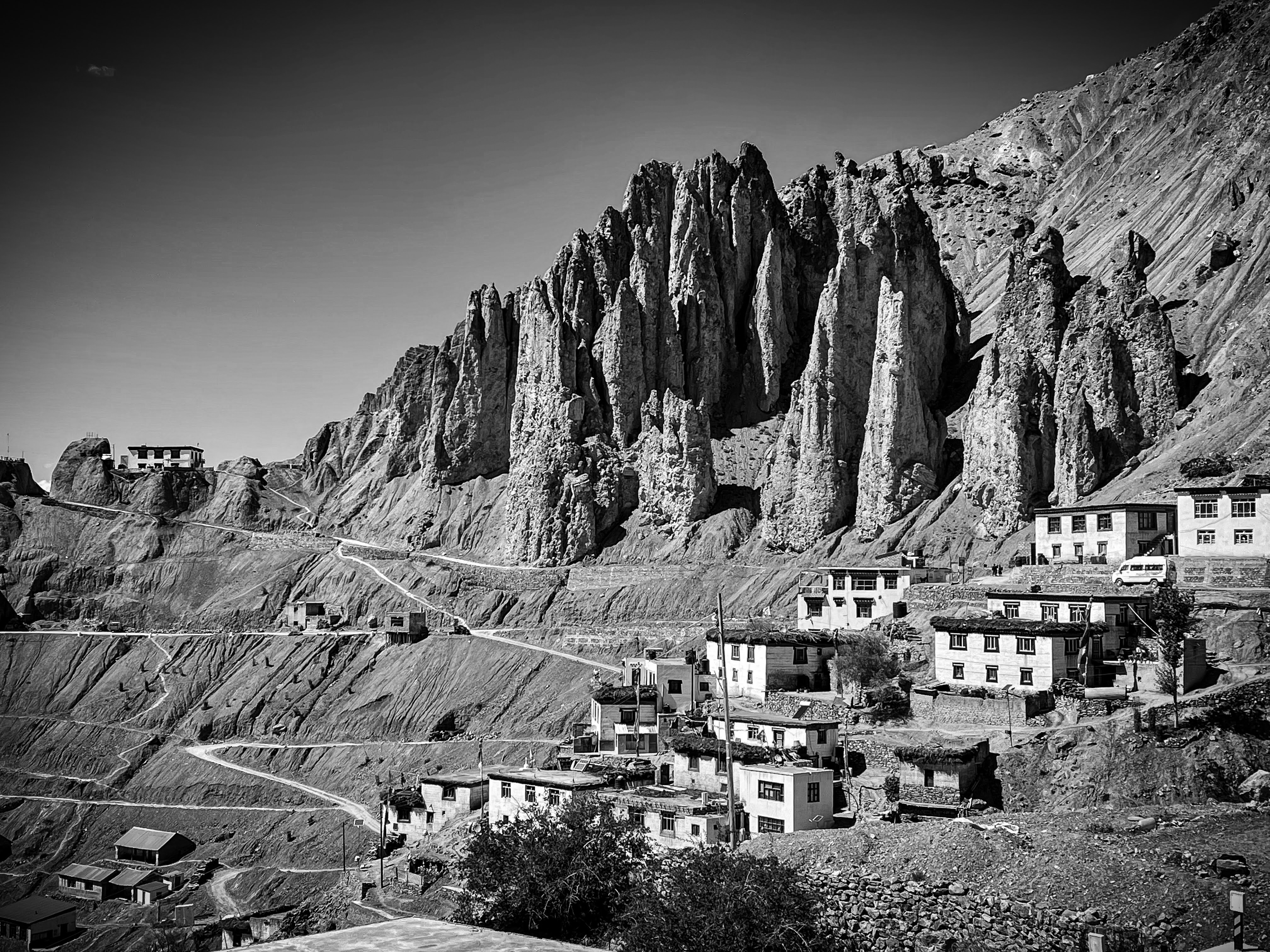 Himalayan village beneath dramatic eroded rock formations