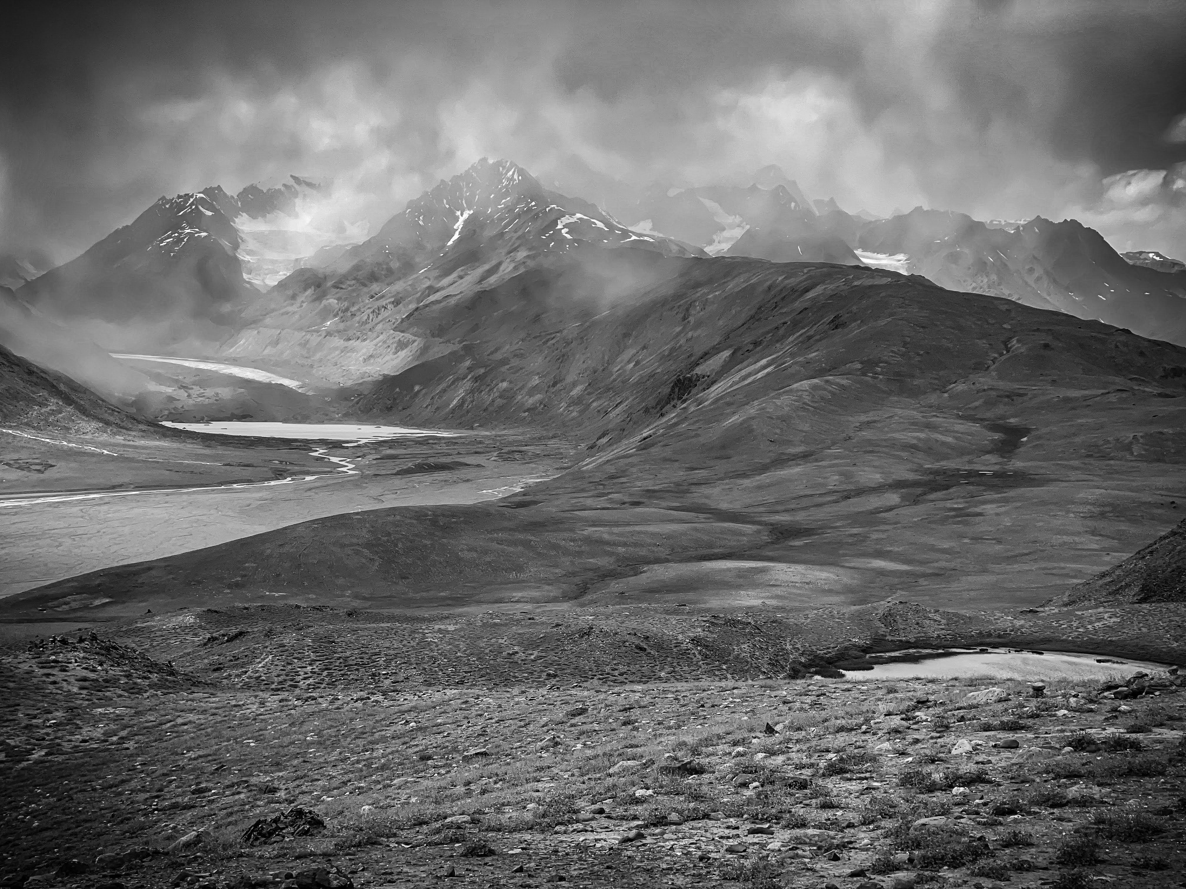 High-altitude plateau with snow peaks and storm light