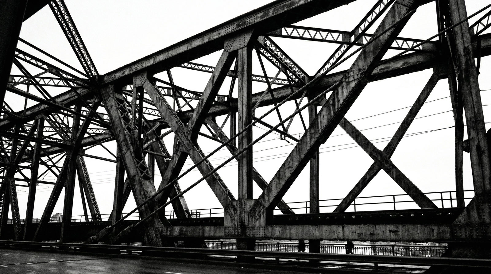 Industrial bridge steel trusses against white sky
