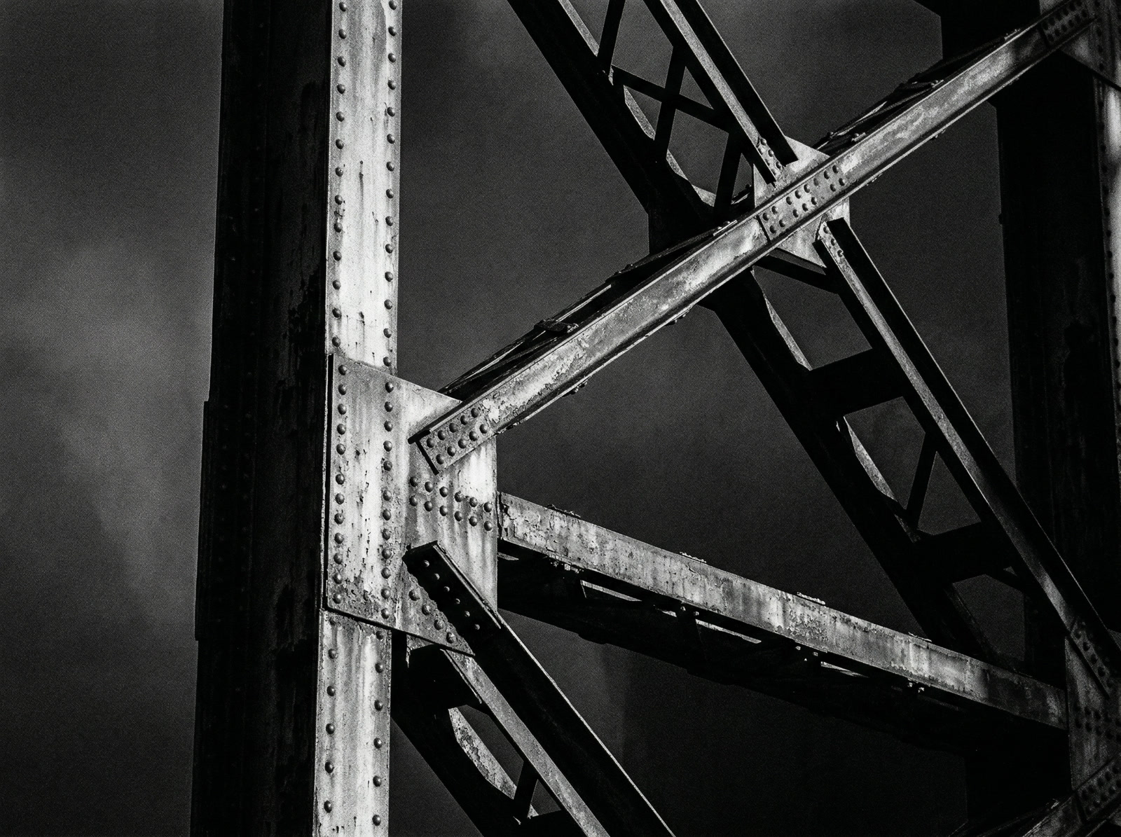 Industrial steel beams and rivets creating geometric patterns